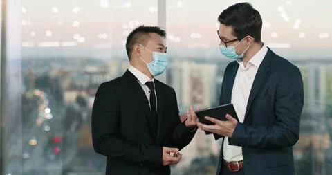 Two mixed-race workers wearing elegant suits having conversation about Stock Footage 244240409