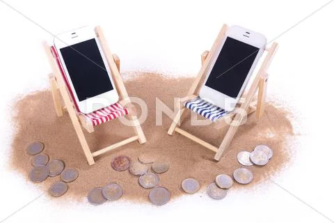 Two mobile phones in toy beach chairs Stock Photos