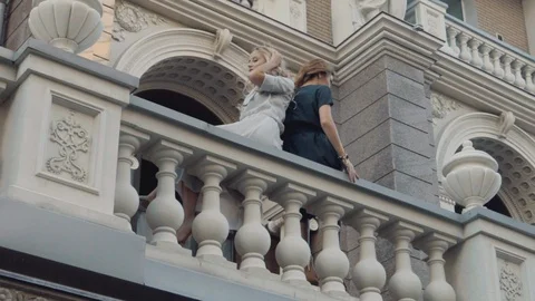 Two models of the girl sit on the gothic railing. Urban fashion. Stock Footage 104479876