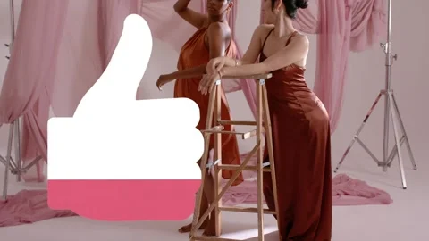 Two models posing on ladder on cue in fashion shoot, thumbs-up overlay filling Stock Footage 333396846