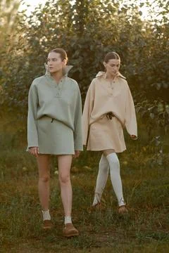 Two models in stylish tracksuits pose in apple orchard at sunset . The model  Foto stock