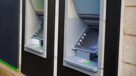Two modern ATMs with sleek design against textured wall background Stock Photos
