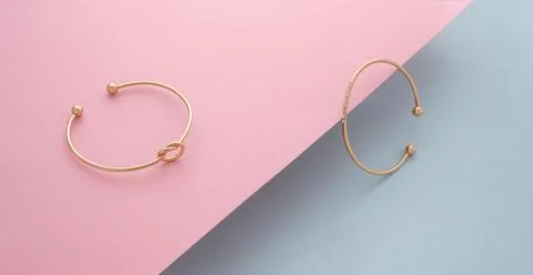 Two modern bracelets on slanted diagonal pink paper on blue background Stock Photos