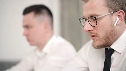 Two modern business men working together in office look at laptop screen and Stock Footage 132297874