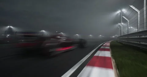 Two modern formula one race cars racing on a speedway at night Stock Footage 245795561