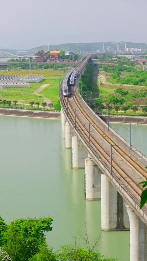 Two modern high-speed trains pass on the railway bridge over the river. Stock Footage 334161105