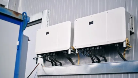 Two modern solar photovoltaic string inverters mounted on factory wall for .. Stock Footage 339766239