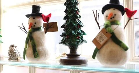 Two Modern Stylized Snowman Figures on a Window Sill with a Christmas Tree Stock Footage 121541631