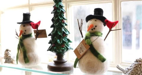 Two Modern Stylized Snowman Figures on a Window Sill with a Christmas Tree Stock Footage 121541644