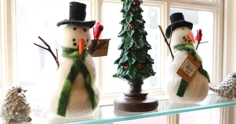 Two Modern Stylized Snowman Figures on a Window Sill with a Christmas Tree Stock Footage 121541652