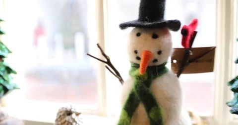Two Modern Stylized Snowman Figures on a Window Sill with a Christmas Tree Stock Footage 121541656