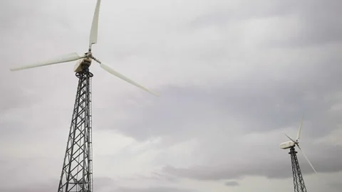 Two modern wind generators, cloudy grey sky bg Stock Footage 97101111