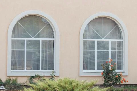 Two modern windows with uv protection curtain on white wall, outdoor view Stock Photos