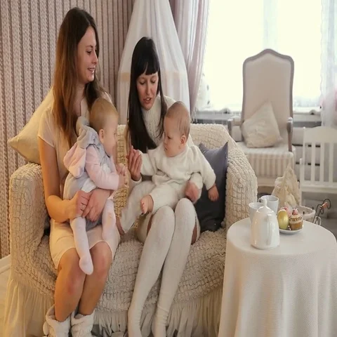 Two mom with little boy and girl sitting on a lounge in Christmas studio Stock Footage 69460367