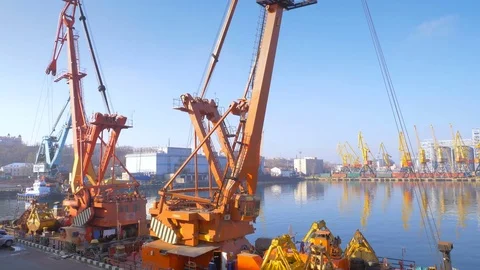 Two moored floating cranes stand in the port in anticipation of a tugboat. 4K. Stock Footage 84321613