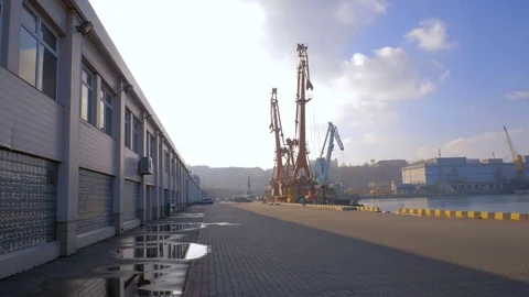 Two moored floating cranes stand in the port in anticipation of a tugboat. 4K. Stock Footage 84323265