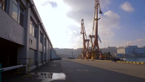 Two moored floating cranes stand in the port in anticipation of a tugboat. 4K. Stock Footage 84329045