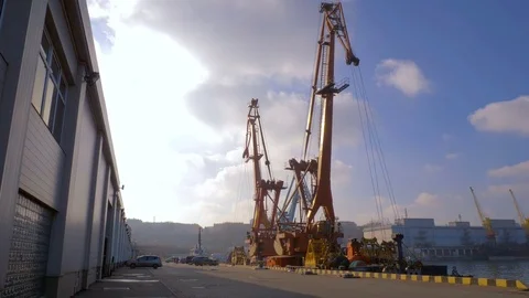 Two moored floating cranes stand in the port in anticipation of a tugboat. 4K. Stock Footage 84329636