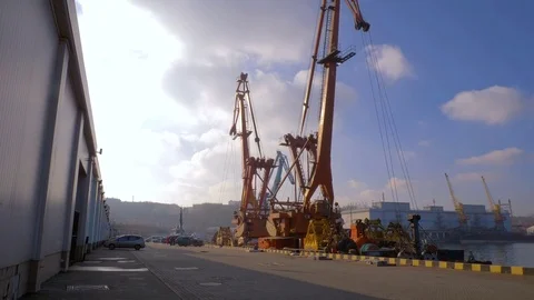 Two moored floating cranes stand in the port in anticipation of a tugboat. 4K. Stock Footage 84330014