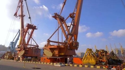 Two moored floating cranes stand in the port in anticipation of a tugboat. 4K. Stock Footage 84332641