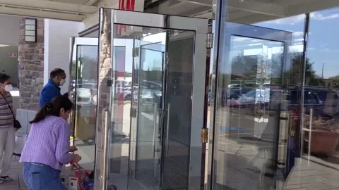 Two mothers with umbrella strollers enter the H&amp;M store at premium outlet mall Vídeo Stock 165960834