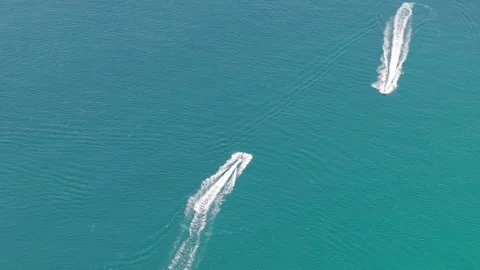 Two motorboats create wake patterns on turquoise water surface from above Video stock 340406773