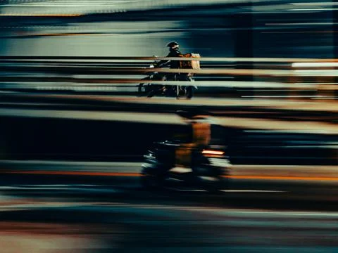 Two Motorcyclists Blurred in Motion Under City Overpass at Night Stock Photos