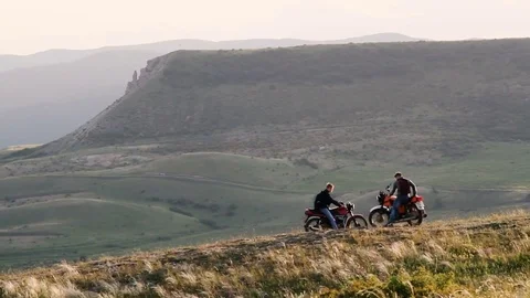 Two motorcyclists on the edge of the hill rest Stock Footage 76876692