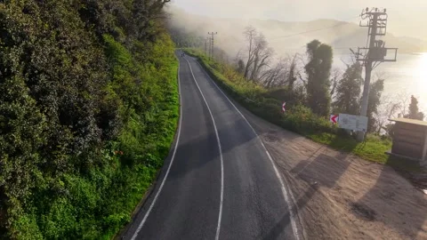 Two Motorcyclists Emerging Through Fog on a Winding Coastal Road in Slow Motion 스톡 동영상 341797047