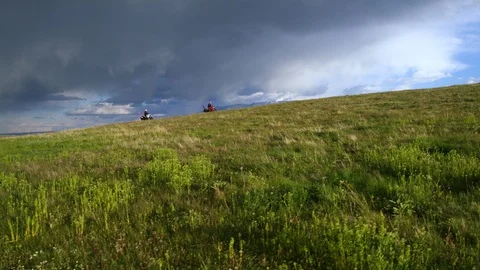 Two motorcyclists riding on horizon with dramatic clouds in Beartooth Mountains Stock Footage 124219042