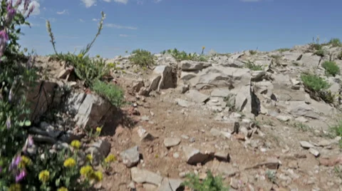 Two mountain bikers cross rocky ridge with Teton Valley, ID in background Stock Footage 36296498