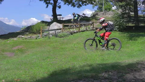 Two mountain bikers have fun with their e-bikes. Stock Footage 137452850