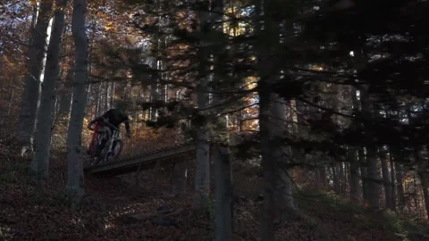 Two mountain bikers MTB mountain bikes catching big air of a wooden jump Stock Footage 150450542