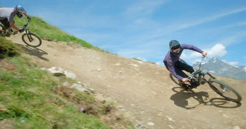 Two mountain bikers riding a high mountain downhill trail. Vídeo Stock 139075189