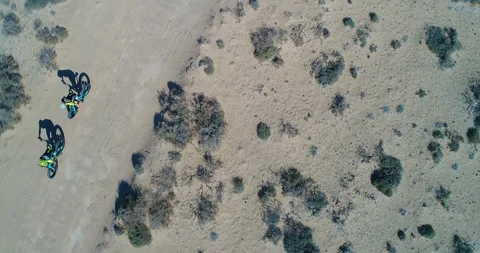 Two Mountain Bikers Riding a Sandy Desert track. Vídeo Stock 85539906