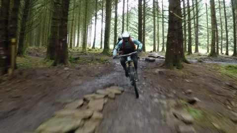 Two mountain bikers turn and go straight off of a rock drop, drone aerial 4K Stock Footage 101107611