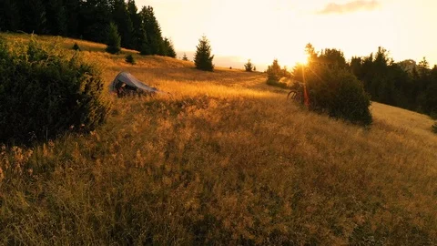 Two mountain bikes and a tent on a mountain meadow at sunrise in autumn 스톡 동영상 119276910