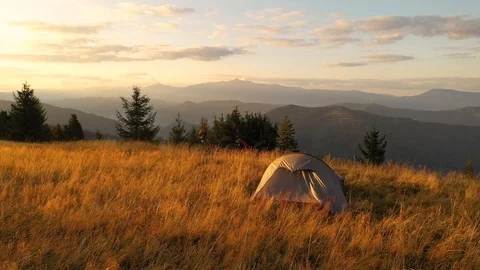 Two mountain bikes and a tent on a mountain meadow at sunrise in autumn 스톡 동영상 119277264