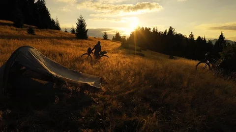 Two mountain bikes and a tent on a mountain meadow at sunrise in autumn 스톡 동영상 119277535
