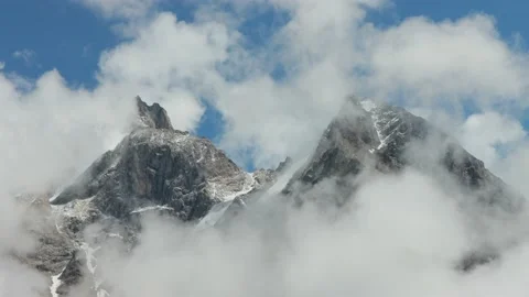 Two mountain peaks view among the white clouds and blue sky. Scenic cloudy Stock Footage 169705668