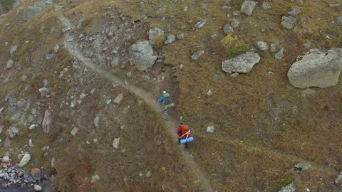 Two mountain tourists with large backpacks are walking in the mountains Stock Footage 259793463