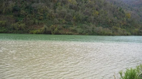 Two mountains rivers with different colors water of clean and dirty merge into Stock Footage 259442736