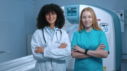 Two MRI specialists posing with arms crossed. Doctor in white gown and Stock Footage 267090890