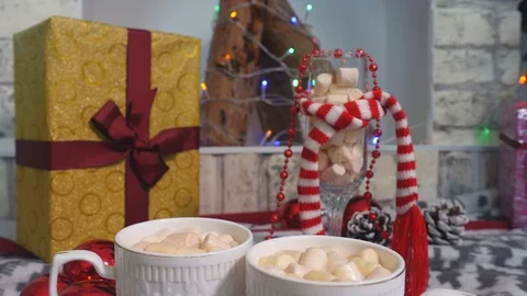 Two mugs with cocoa and marshmallows are on the Christmas table drinks by young Stock Footage 116304412