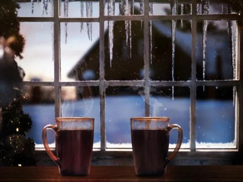 Two mugs with coffee on a background of a winter window. Snow falling, icicle Stock Photos