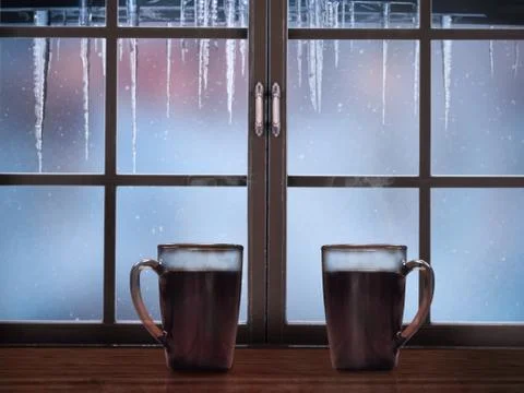 Two mugs with coffee on a background of a winter window Stock Photos