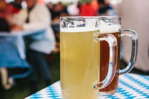 Two mugs with a light and dark beer stand on the table. In the background Foto stock