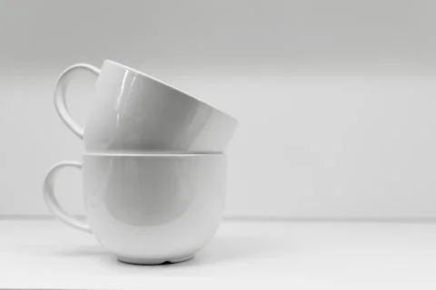 Two mugs on a white background are standing. Stock Photos