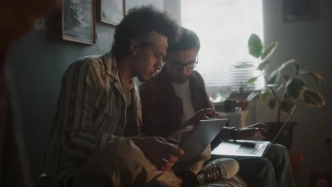 Two Multi-ethnic Friends Programming on Laptops while Sitting Together Stock Footage 290869180