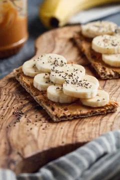 Two multi grain breads with peanut paste, banana slices and chia seeds on a s Stock Photos